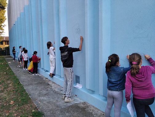 ragazzi che dipingono sul palazzetto dello sport durante un laboratorio di murales di Goran castellotti